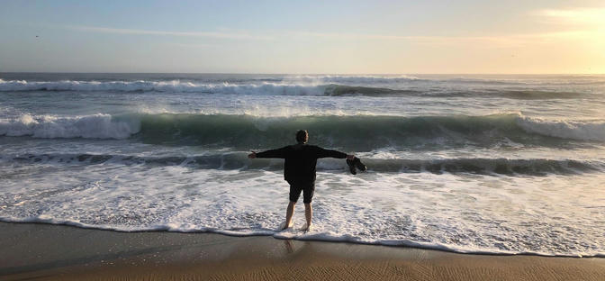 Me, arms outstretched, facing away towards the ocean.